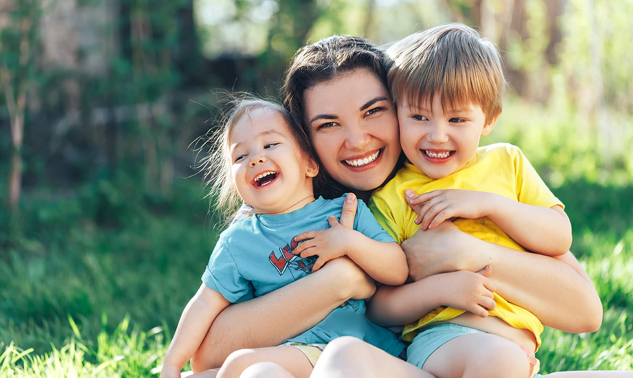 mom and two kids hugging and smiling