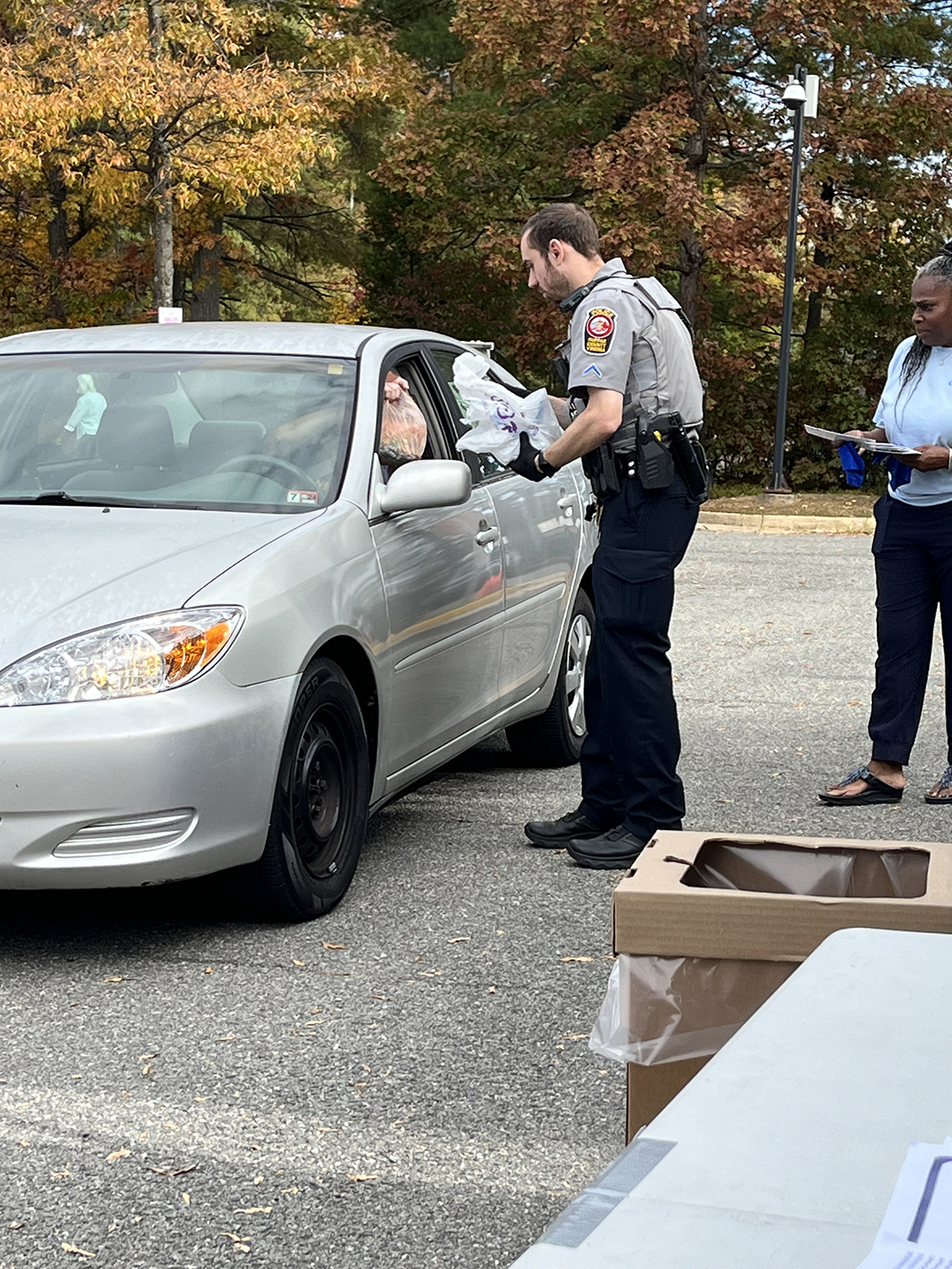 officer collecting prescription drug bag from resident at drop-off location