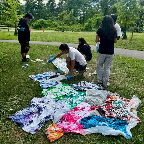 members of the FPC Coalition create tie-dye shirts that say Carry Narcan