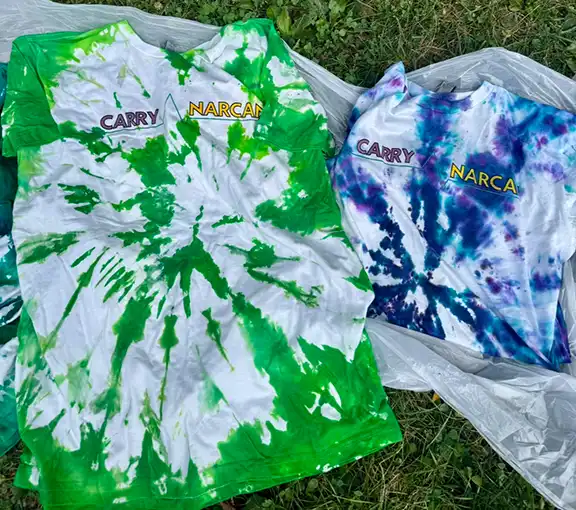 members of the FPC Coalition create tie-dye shirts that say Carry Narcan
